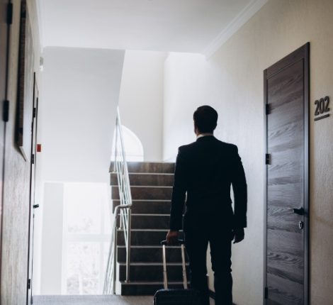 businessman-walking-with-luggage-in-a-hotel-corrid-2025-02-21-11-17-57-utc (1)